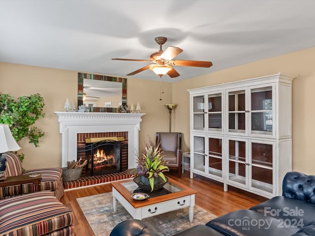 living room with hardwood / wood-style flooring, ceiling fan, and a fireplace