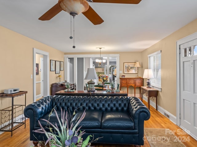 living room featuring hardwood / wood-style floors and ceiling fan with notable chandelier