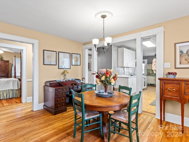 dining area featuring light hardwood / wood-style flooring and a notable chandelier