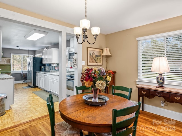 dining space with a chandelier and light parquet floors