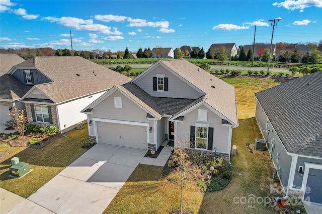 view of front of property featuring a garage, a front yard, and central AC