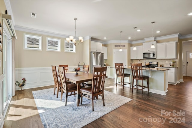 dining space featuring crown molding, dark hardwood / wood-style floors, and an inviting chandelier