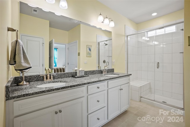 bathroom featuring tile patterned flooring, vanity, and walk in shower