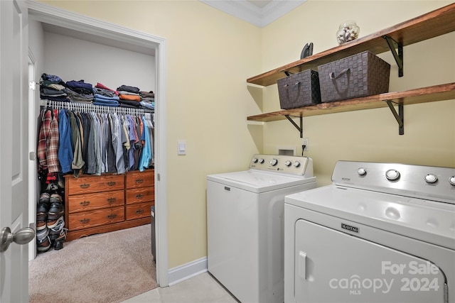 laundry room featuring independent washer and dryer, ornamental molding, and light carpet