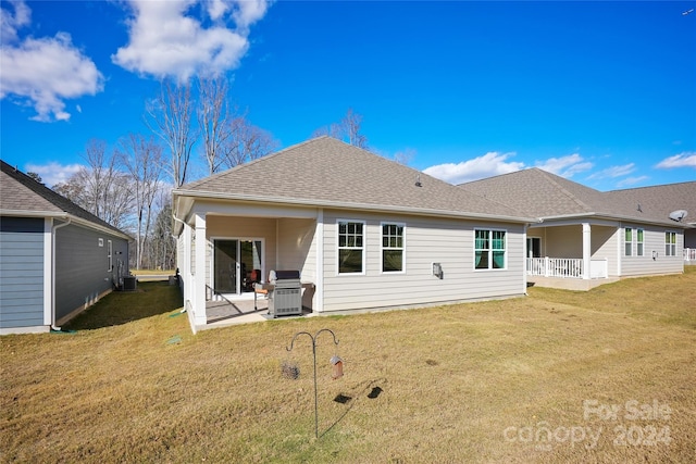 rear view of house with a lawn and a patio