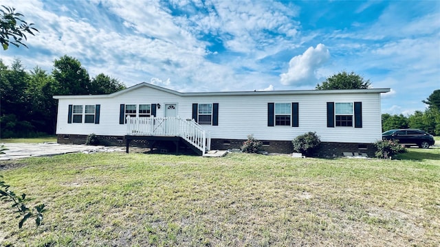 manufactured / mobile home with a deck and a front yard