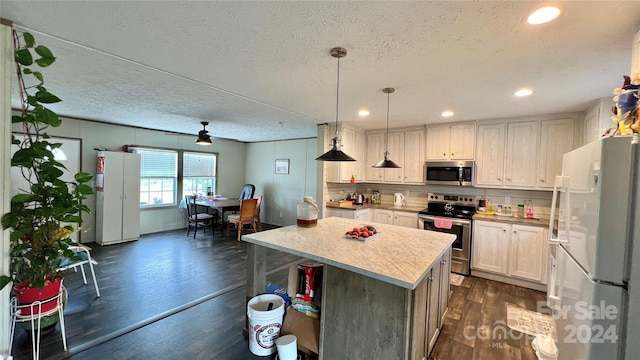 1824 Germantown Pl, Dillon, SC 29536 - kitchen with appliances with stainless steel finishes, dark wood-style floors, light countertops, a kitchen island, and hanging light fixtures