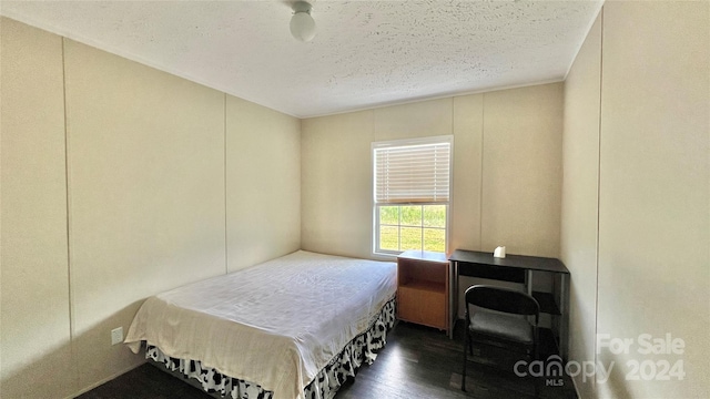 bedroom featuring dark hardwood / wood-style flooring and a textured ceiling