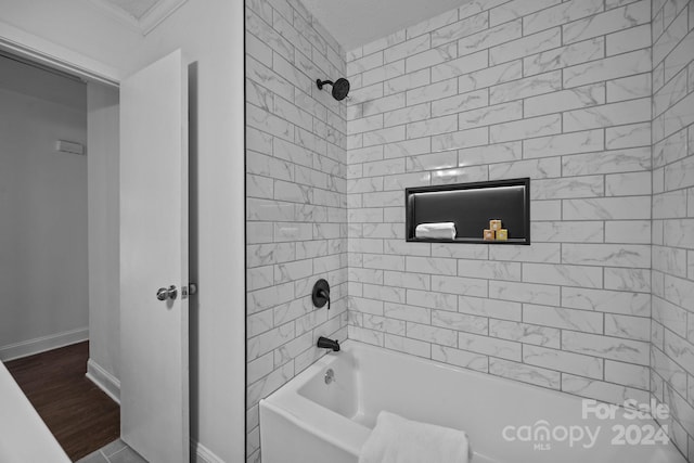 bathroom with hardwood / wood-style floors, tiled shower / bath combo, and crown molding