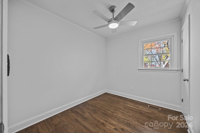 unfurnished room with ornamental molding, ceiling fan, and dark wood-type flooring