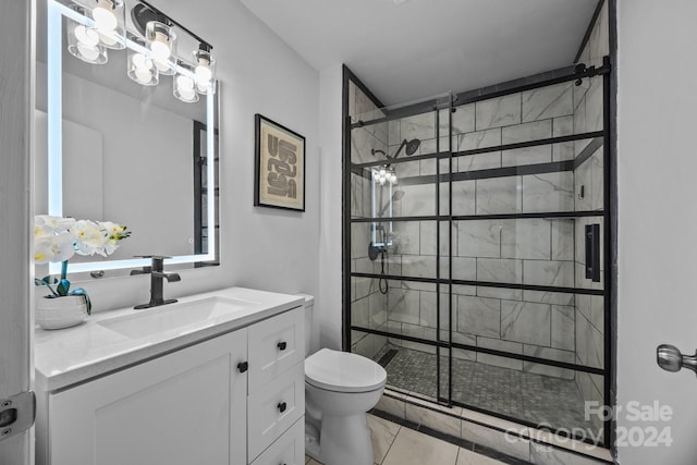 bathroom with toilet, tile patterned flooring, vanity, and tiled shower