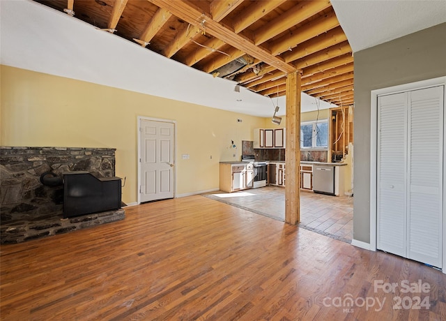 unfurnished living room with light hardwood / wood-style flooring and beamed ceiling