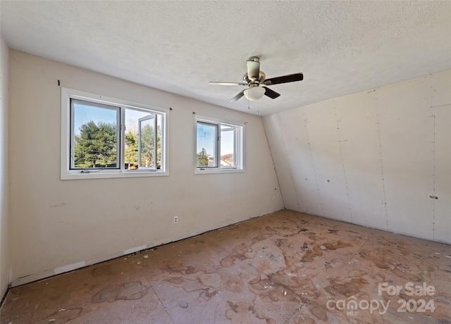 empty room featuring ceiling fan and a textured ceiling