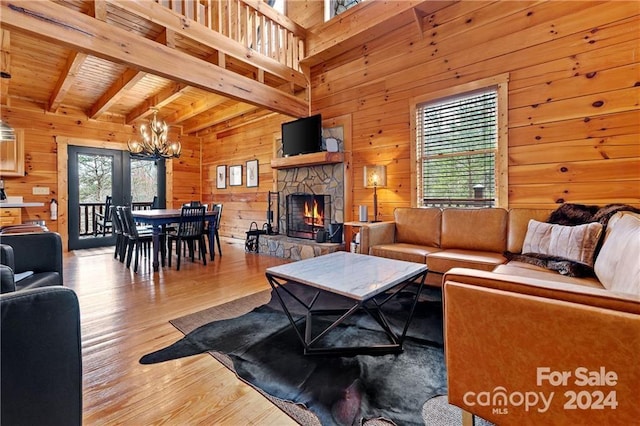 552 Lake Rd, Old Fort, NC 28762 - living room with wooden walls, a chandelier, a stone fireplace, wood finished floors, and wood ceiling with exposed beams
