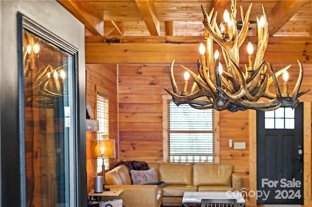 living room with beam ceiling, wood ceiling, wooden walls, and an inviting chandelier