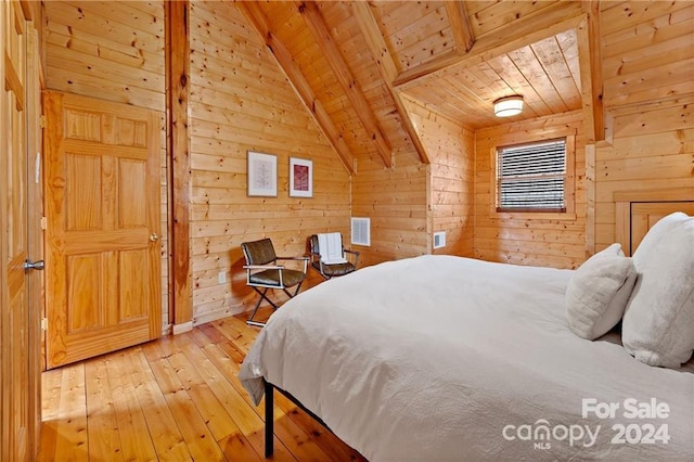 bedroom with hardwood / wood-style flooring, lofted ceiling with beams, and wood walls