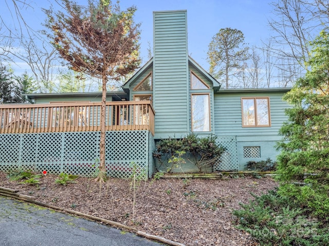 view of side of home featuring a deck and a chimney