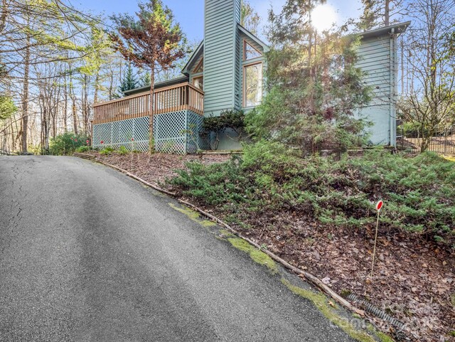 view of home's exterior featuring a chimney and a wooden deck