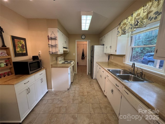 kitchen featuring stainless steel appliances, a sink, and white cabinets