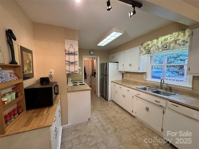 kitchen with freestanding refrigerator, white cabinets, a sink, black microwave, and dishwasher