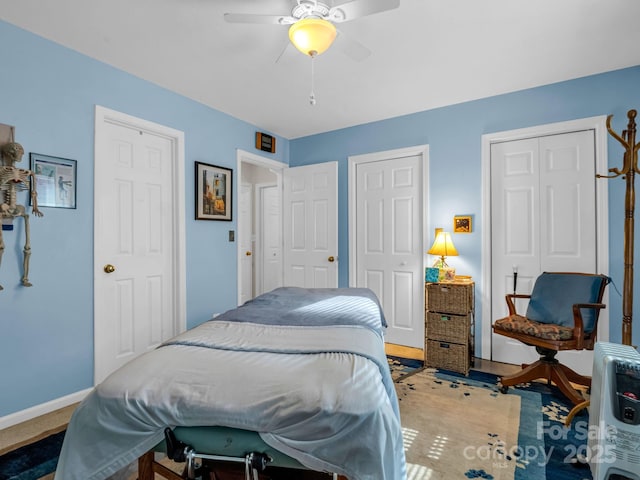 bedroom featuring ceiling fan, baseboards, and two closets