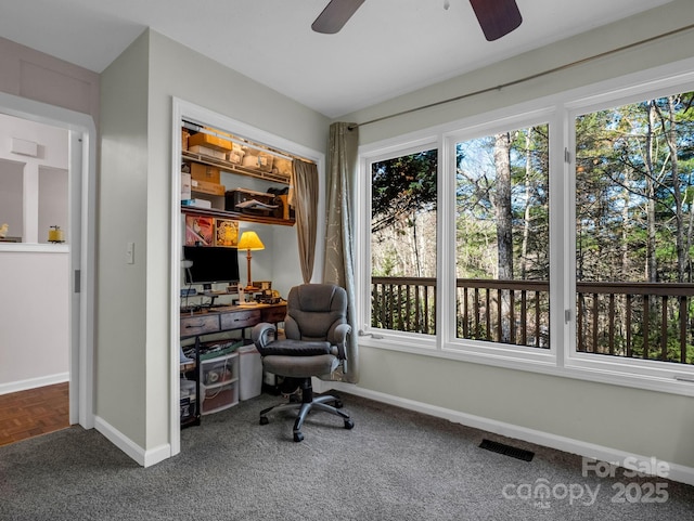 carpeted office featuring baseboards, visible vents, and ceiling fan