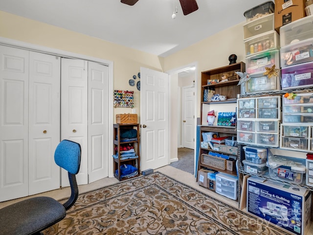 carpeted office space with a ceiling fan