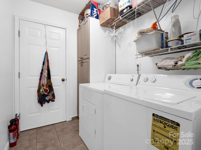 clothes washing area featuring light tile patterned flooring, cabinet space, and separate washer and dryer