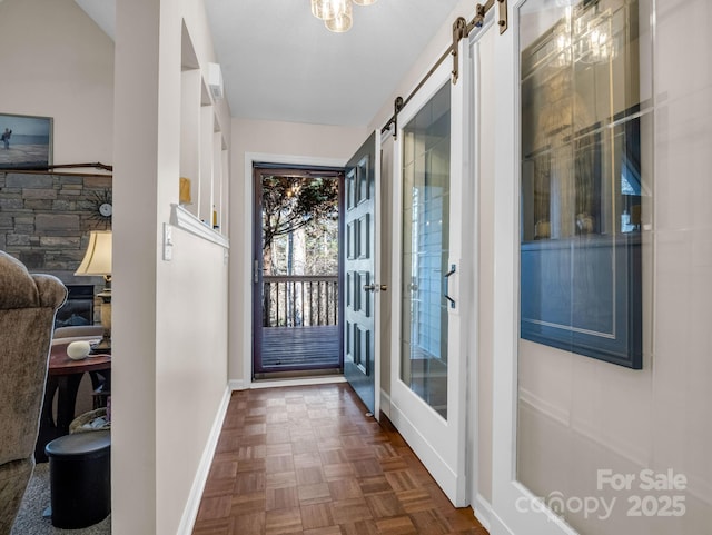 entryway with baseboards and a barn door