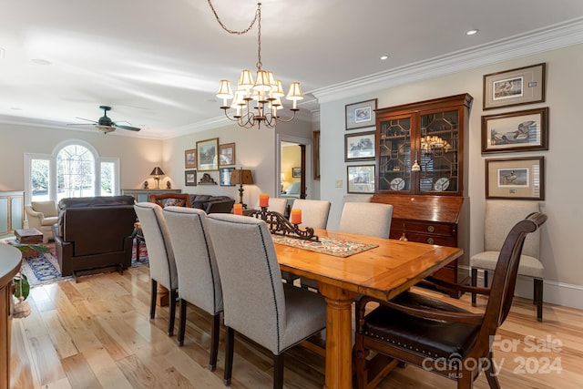 dining space with ceiling fan with notable chandelier, light hardwood / wood-style flooring, and ornamental molding