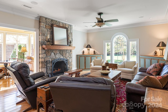 living room with ceiling fan, a fireplace, ornamental molding, and hardwood / wood-style flooring