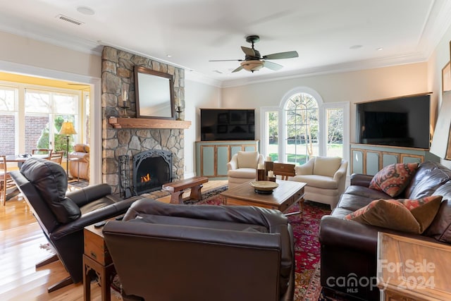 living room with a fireplace, ceiling fan, hardwood / wood-style floors, and ornamental molding