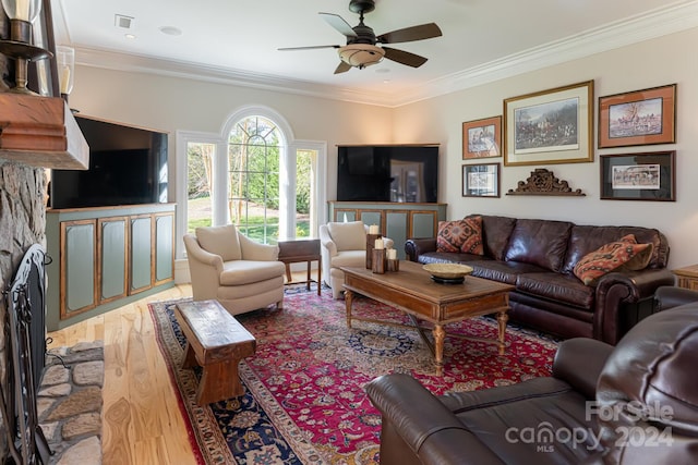 living room with hardwood / wood-style flooring, ceiling fan, a fireplace, and crown molding