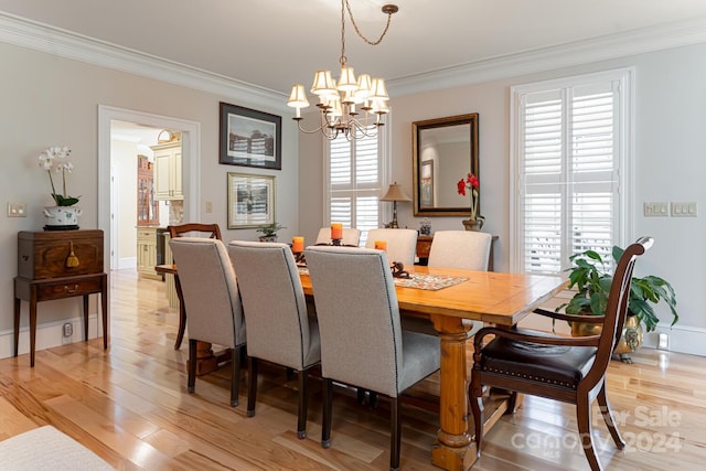 dining area with light hardwood / wood-style flooring, a chandelier, and ornamental molding