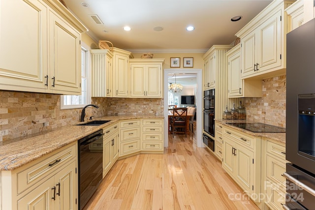 kitchen with cream cabinets, sink, black appliances, and ornamental molding