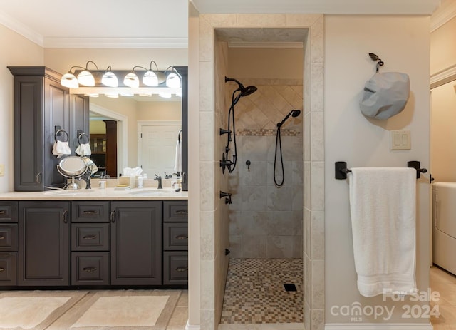 bathroom with tiled shower, vanity, crown molding, and tile patterned flooring