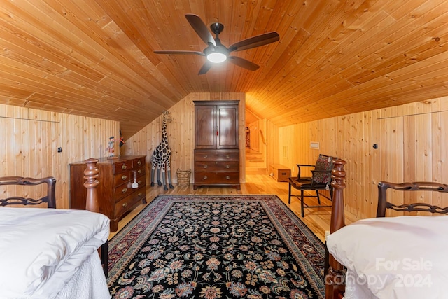 bedroom featuring wooden walls, wooden ceiling, ceiling fan, and lofted ceiling