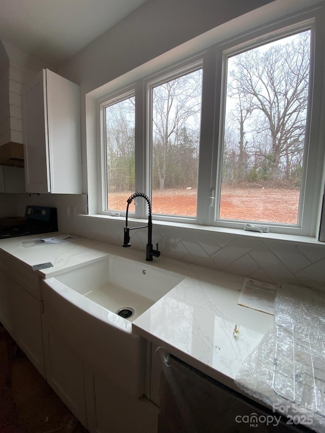 kitchen featuring white cabinetry, sink, light stone counters, and electric range oven