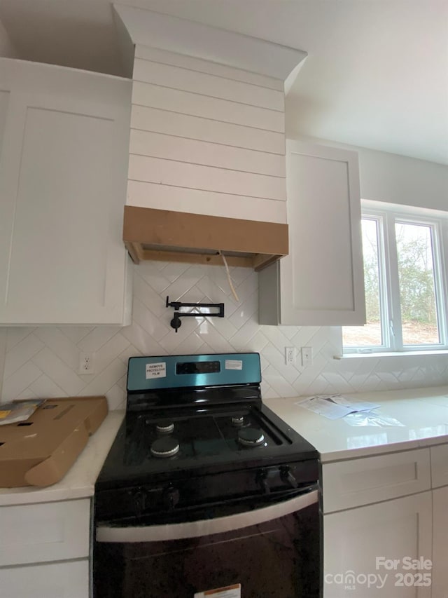 kitchen with white cabinets, decorative backsplash, and electric range