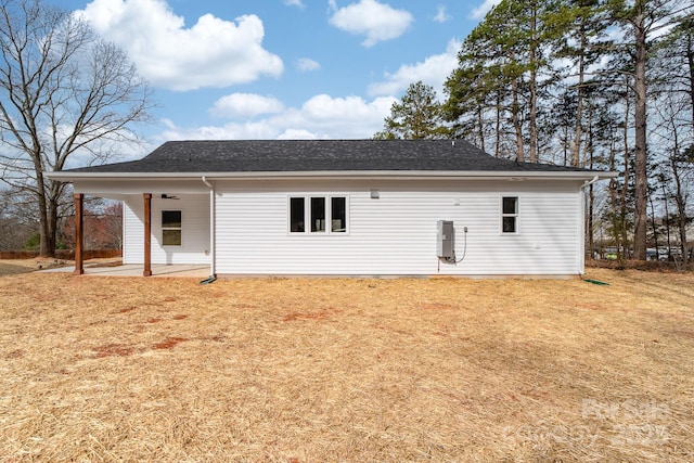 back of house with a patio area, a yard, a shingled roof, and a ceiling fan