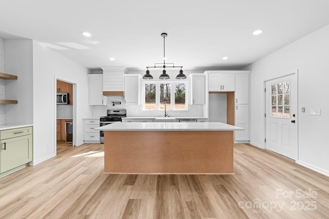 kitchen featuring a healthy amount of sunlight, stainless steel appliances, light countertops, and open shelves