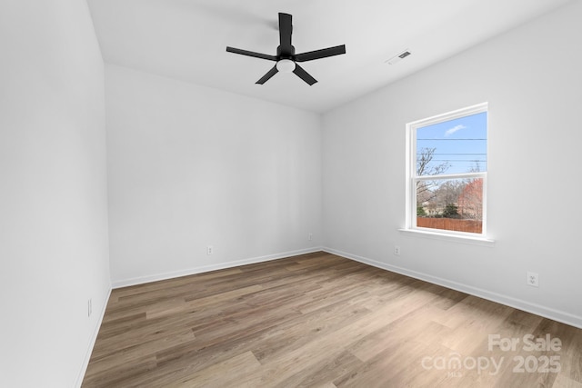 unfurnished room with visible vents, baseboards, ceiling fan, and wood finished floors