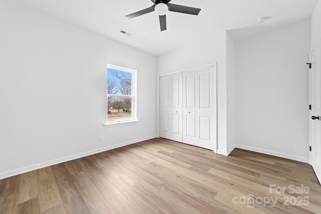 unfurnished bedroom featuring a closet, visible vents, baseboards, and light wood-style floors