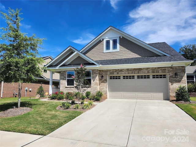 craftsman house featuring a front yard and a garage