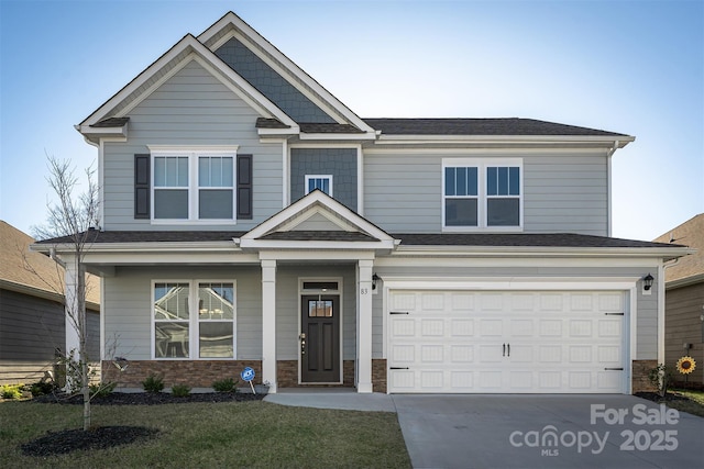 craftsman inspired home featuring a porch, a front yard, and a garage