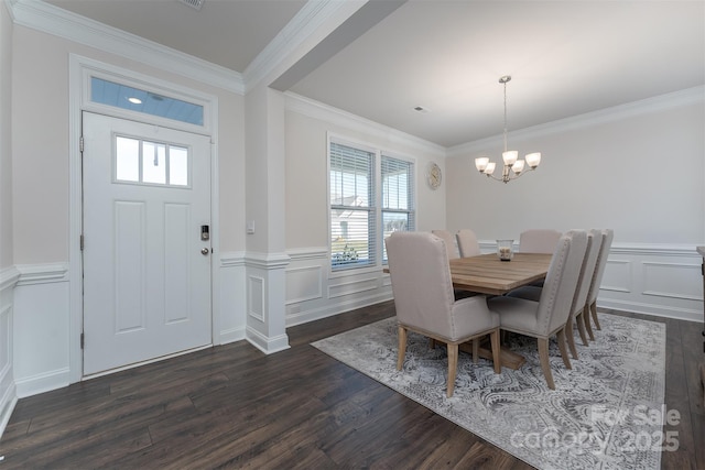 dining room featuring dark hardwood / wood-style flooring, ornamental molding, and an inviting chandelier