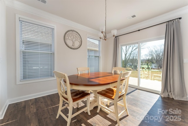 dining area featuring crown molding, dark wood-type flooring, and a notable chandelier