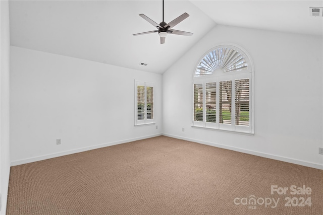 spare room featuring carpet, a healthy amount of sunlight, and lofted ceiling