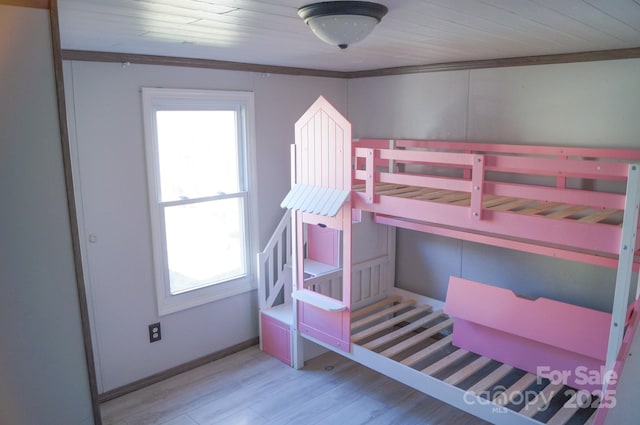 bedroom with crown molding, wood ceiling, and light wood-type flooring