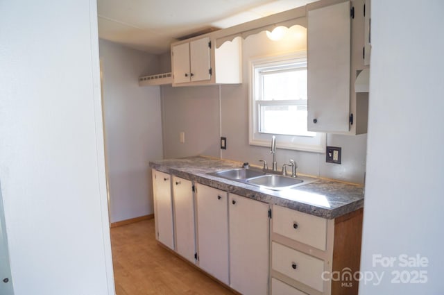 kitchen featuring cream cabinets, light wood-type flooring, and sink